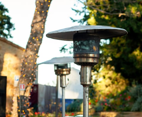 Outdoor heaters providing warmth on a chilly evening in a garden setting, creating a cozy and inviting atmosphere