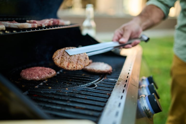 Grilling burgers and sausages outdoors in the backyard